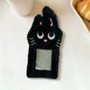 A black plush cat photocard holder with pink accents and a clear window is displayed on a white surface.