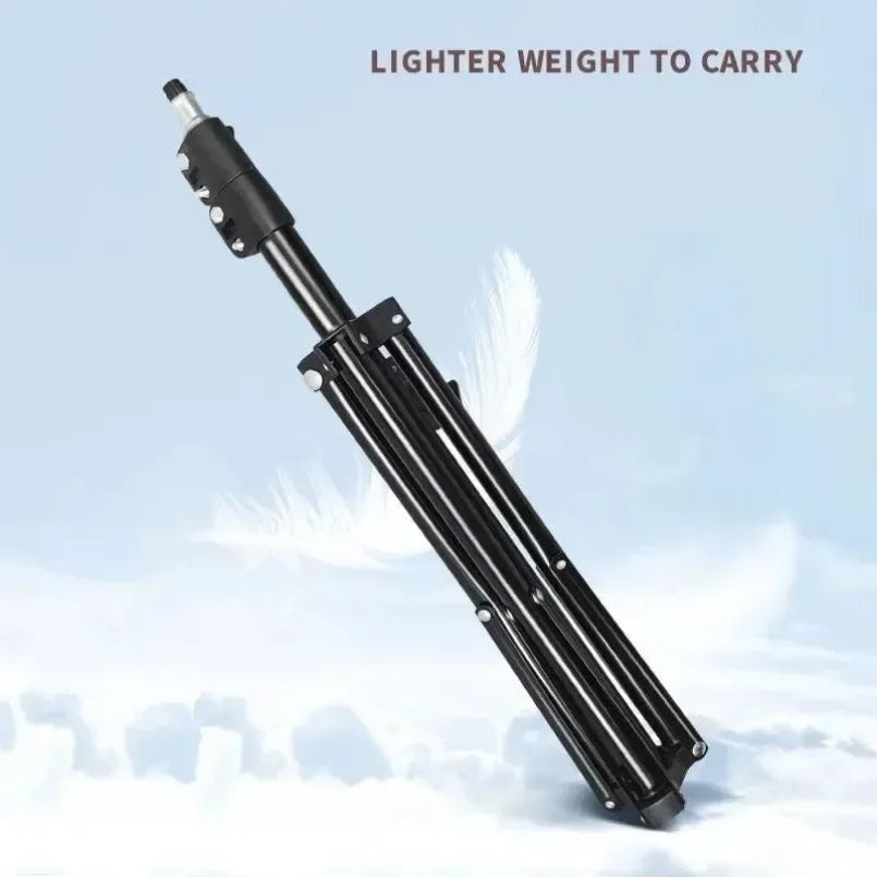A black adjustable phone tripod is shown against a light blue sky with clouds.