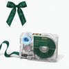 A clear label maker device with a dark green ribbon and ink cartridge is shown next to a bow.