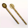 Vintage brass straight ruler with a leaf pattern design and a round measuring spoon.