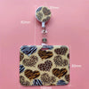 A leopard print card holder clip featuring a heart design, shown against a pink background.