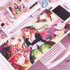 A pink and purple anime-themed mouse pad and desk mat featuring characters on a white surface.
