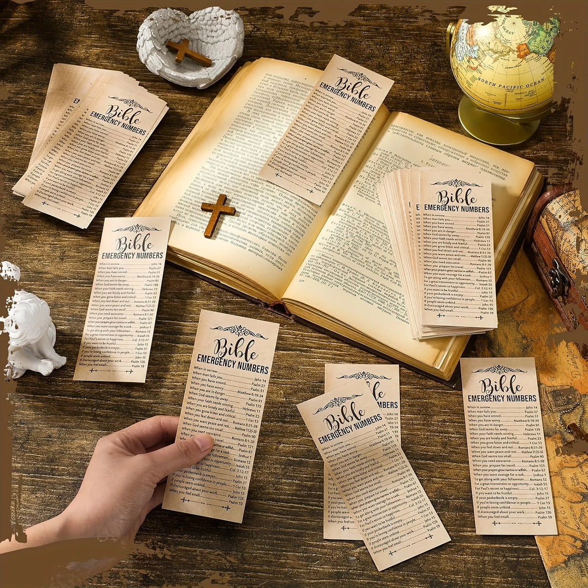 A collection of decorative bible verse bookmarks and an open Bible are displayed on a wooden surface.