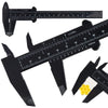 A black precision eyebrow measuring caliper with a ruler scale and yellow pom-pom for permanent makeup application.