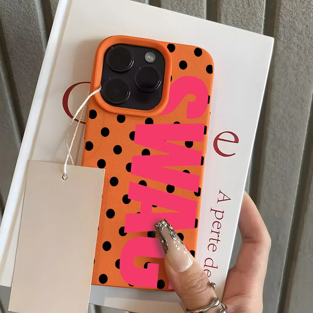A pink and orange polka dot phone case with a clear back showing the brand name SWAG