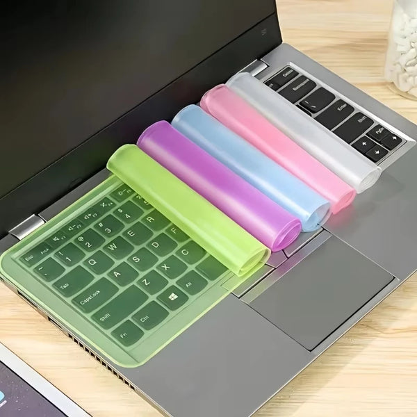 Un clavier d'ordinateur portable avec plusieurs caches de clavier en silicone colorés, vert, violet, bleu et rose.
