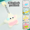 A white plush pendant featuring a pink nose and blue accents, shown alongside similar colored versions.