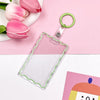 Clear acrylic card holder with a green keychain attached, set against a pink background.