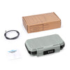 A portable combination lock box in gray plastic with a lid and an instruction manual and cardboard packaging box.