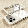 A clear acrylic phone case with a built-in MagSafe holder and multiple camera cutouts resting on a textured surface.