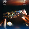A hand holds a roll of decorative PET washi tape featuring gold and iridescent floral designs against a dark background.