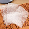 Transparent bubble wrap padded shipping bags are laid out on a woven basket.