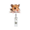 A small brown and white hamster is attached to a clear acrylic badge reel with a retractable clip.