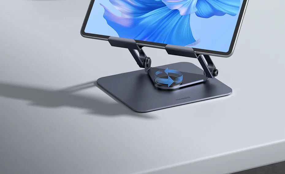 A dark gray tablet stand holding a tablet displaying a blue floral design.