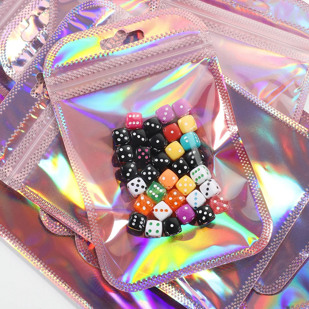 A collection of colorful and black iridescent self-sealing jewelry pouches filled with various small stones.