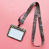A leopard print ID holder lanyard keychain with a white card attached, set against a pink background.