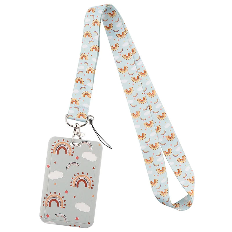 A light blue patterned fabric lanyard with a rectangular tag attached, featuring a rainbow and cloud design.