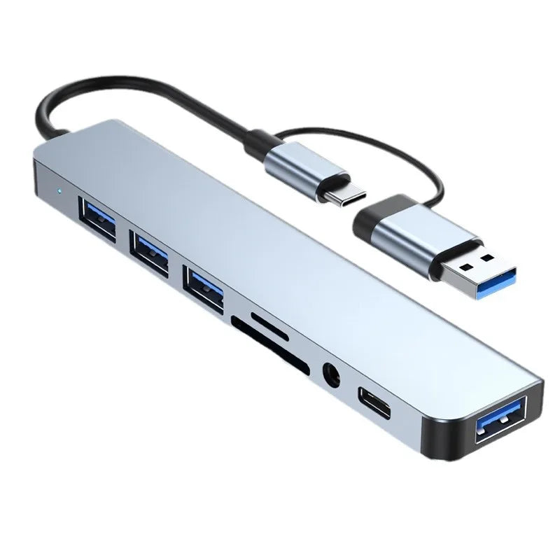 Silver multi-port USB-C hub adapter with multiple USB ports and an audio jack