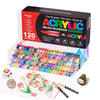 A box of acrylic brush markers with various colors and tips, alongside some individual markers and a sheet of paper.