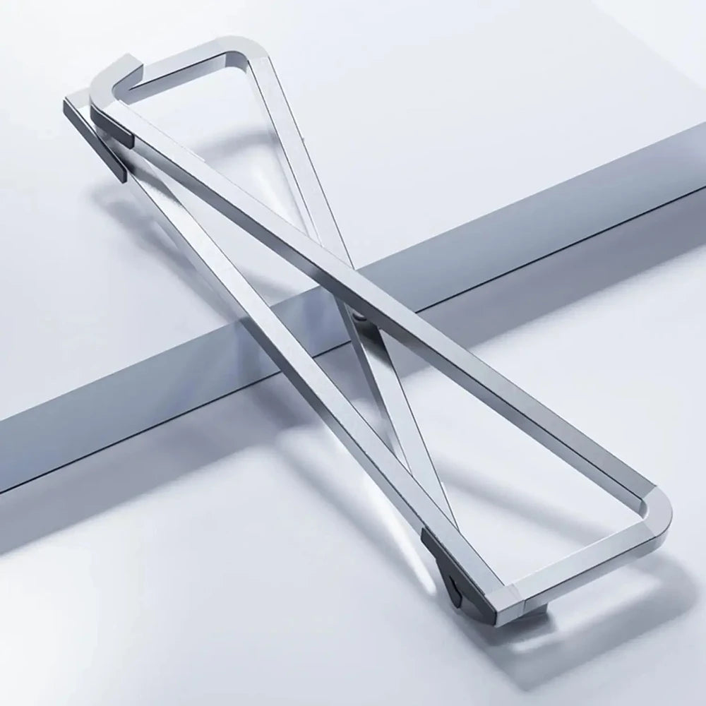 A silver foldable aluminum laptop stand with a non-slip grip shown in a diagonal angle.