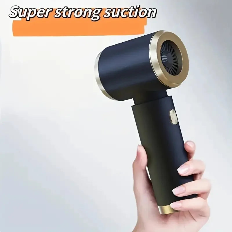 A hand is holding a black and gold portable dual-purpose rechargeable vacuum cleaner with a strong suction nozzle.