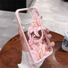 A hand holds a pink floral transparent iPhone case featuring a pink lily design.