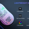 A lightweight honeycomb gaming mouse with pink and green accents shown next to a keyboard.