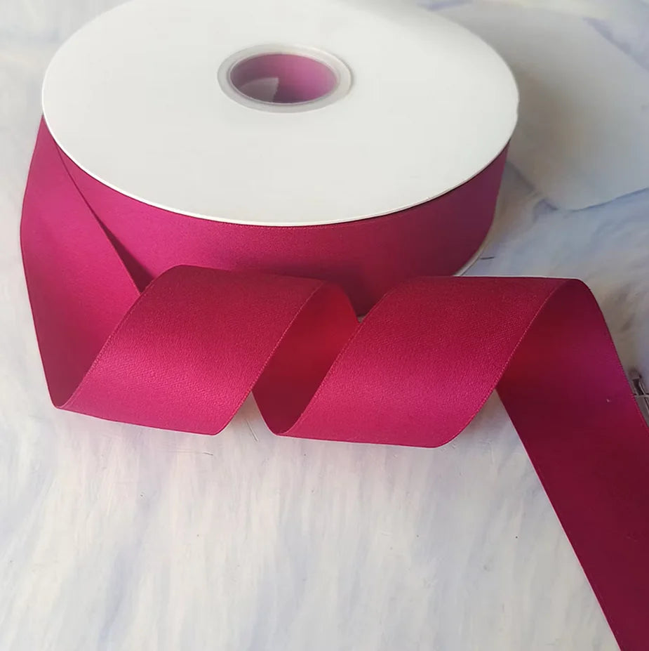 Roll of matte finish satin ribbon in a deep magenta color