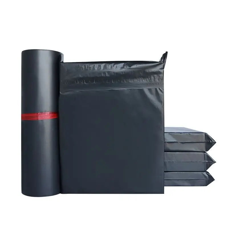 A roll of black poly mailers next to a stack of black self-sealing shipping bags.