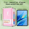 Pink spiral-bound weekly and monthly planner for the year 2027 next to an iPad