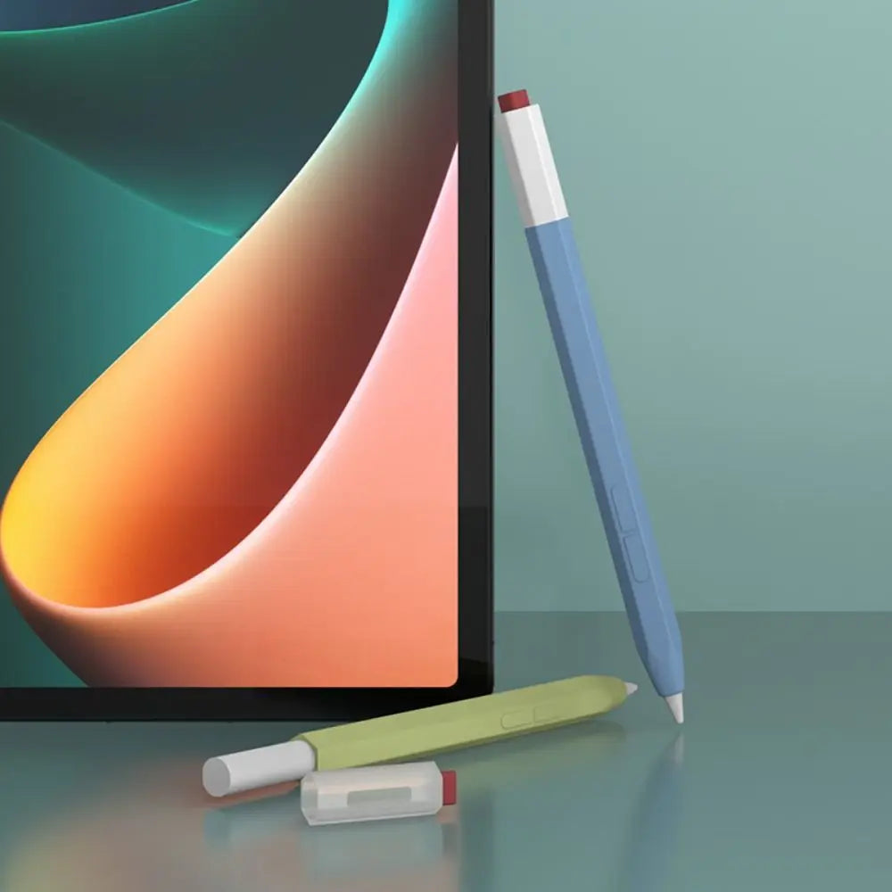 A blue stylus pen with a red cap rests next to a laptop screen and a light green protective cover.