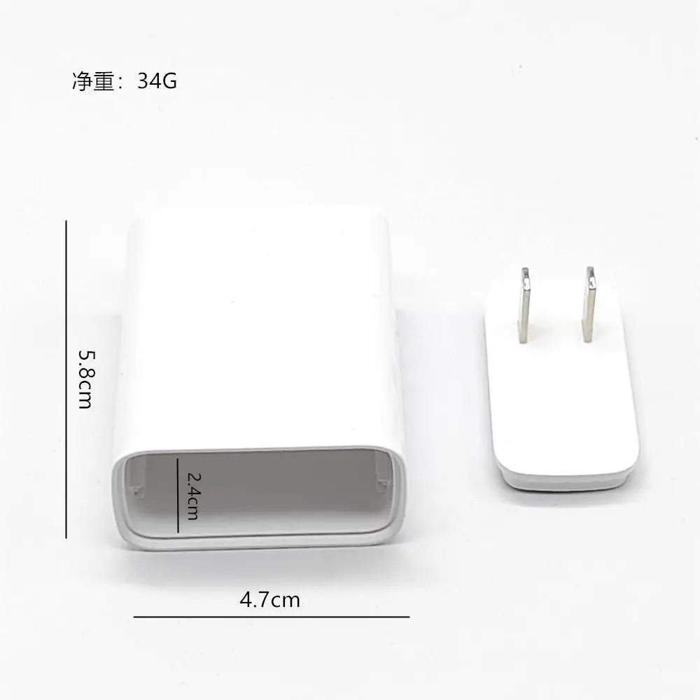 A white storage charger plug with a silver compartment and two pins is shown next to a measurement scale.