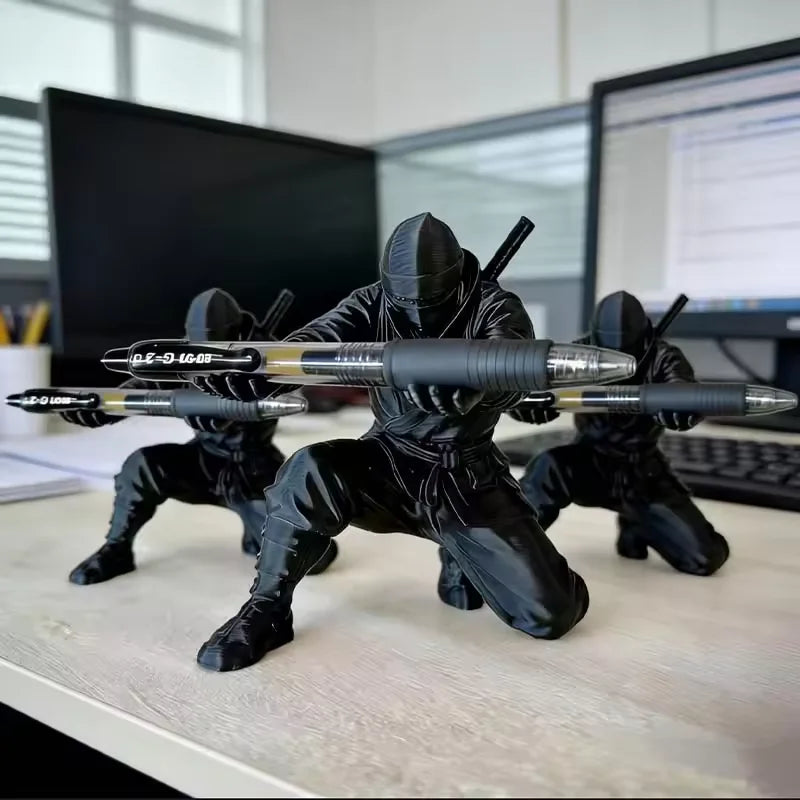Matte black ninja figurine pen holder with weapons displayed on a white desk.