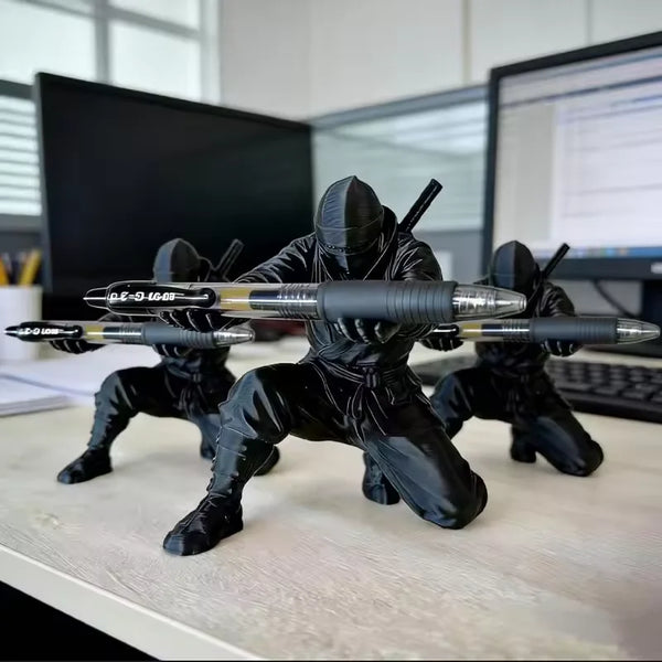 Matte black ninja figurine pen holder with weapons displayed on a white desk.