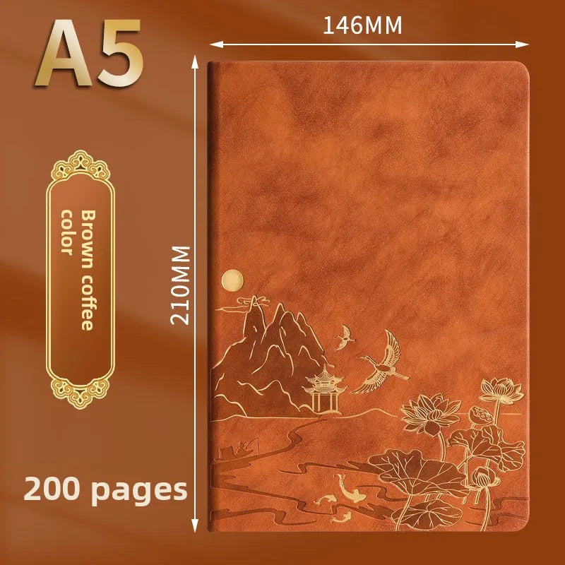 A brown leather-bound notebook with an illustrated landscape featuring mountains, a pagoda, and flowers.