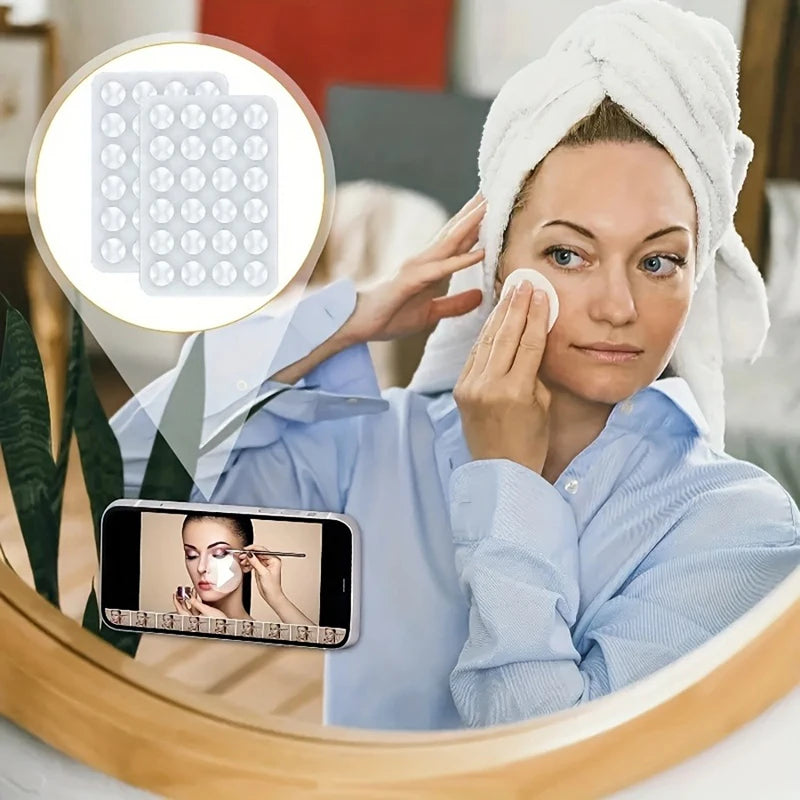 A woman uses a silicone suction phone mount to take a selfie in a mirror.