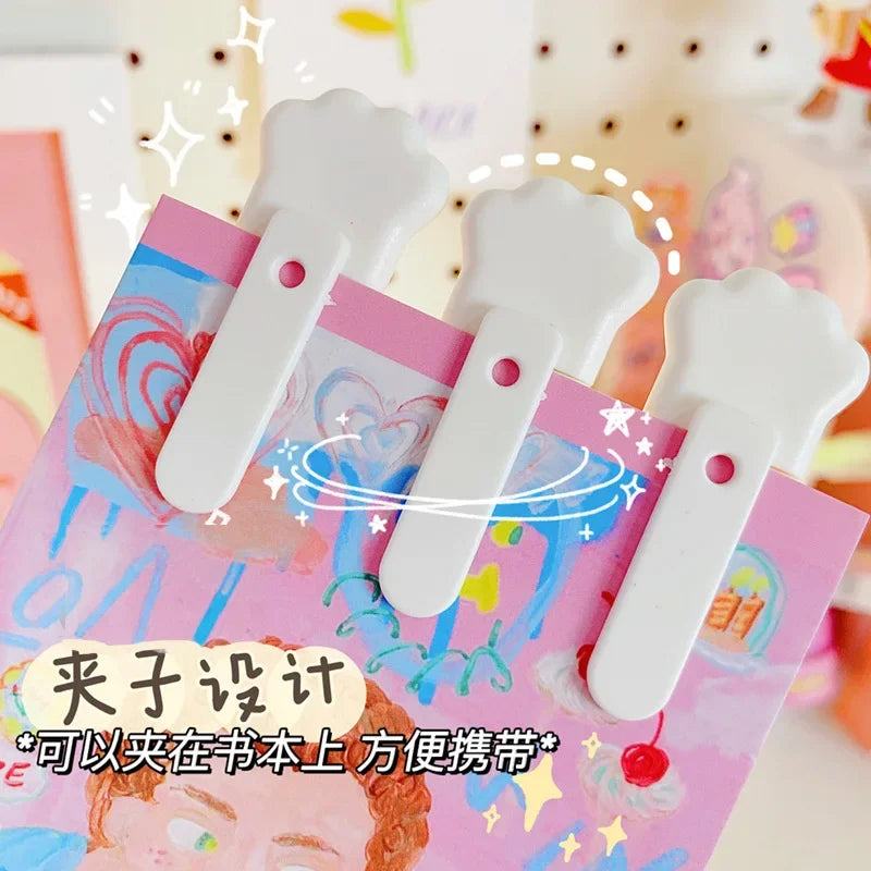 White cat paw mini cutter tool shown on a pink background for mail and crafts