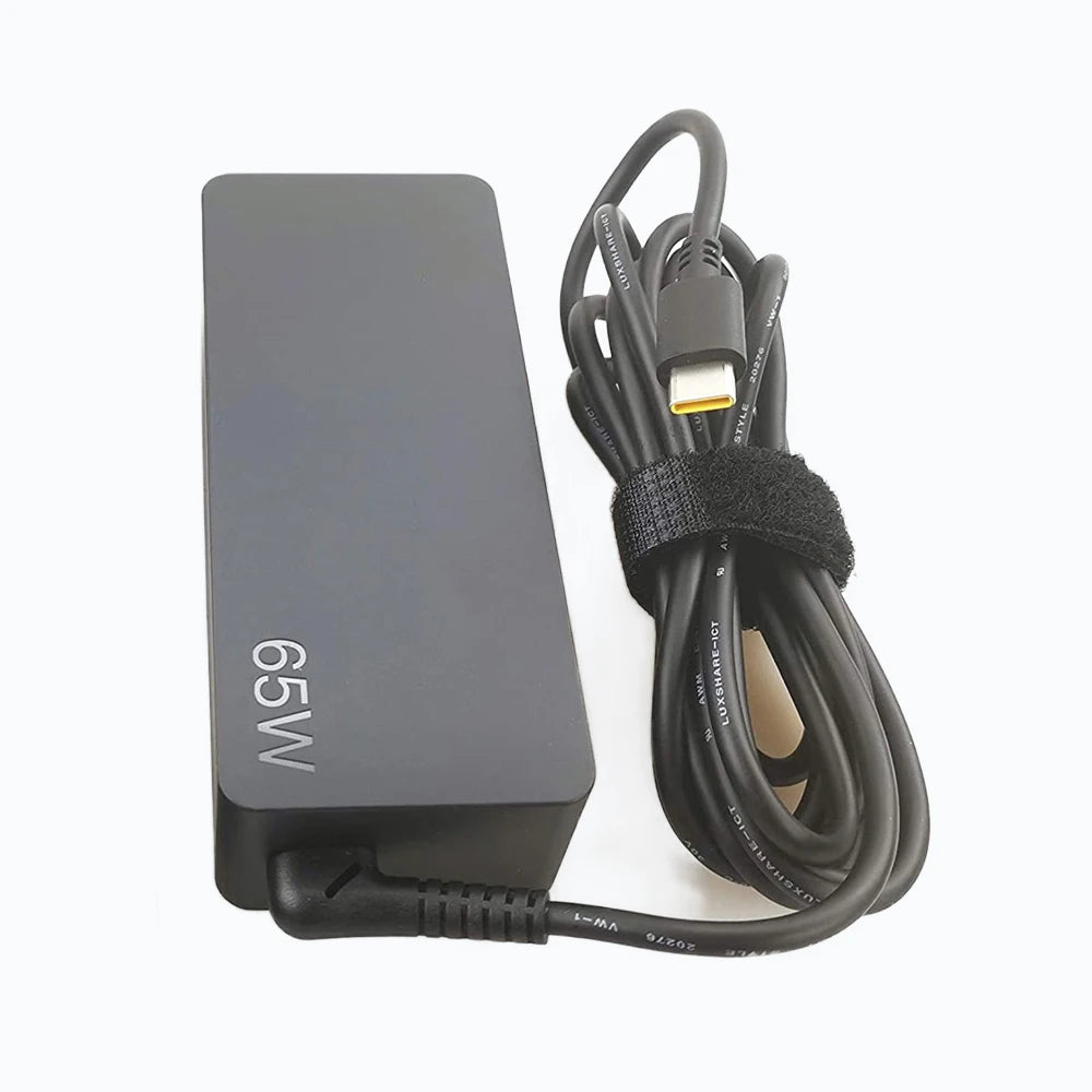 A black 65W USB-C AC adapter with a coiled cable and a yellow connector.