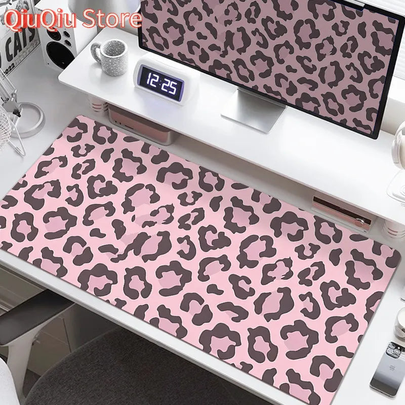 A large leopard print desk pad featuring pink and black spots is displayed on a white shelf.