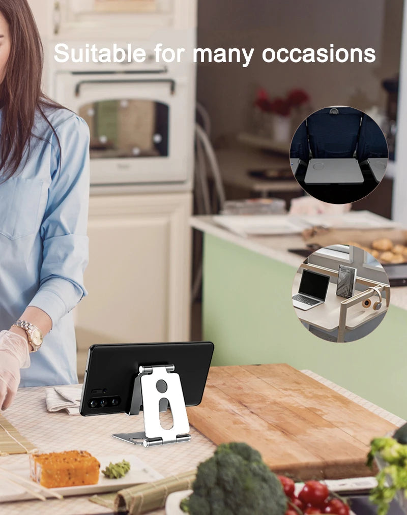 Un support de téléphone portable en métal sur un bureau en bois à côté d'un ordinateur portable et de divers aliments.