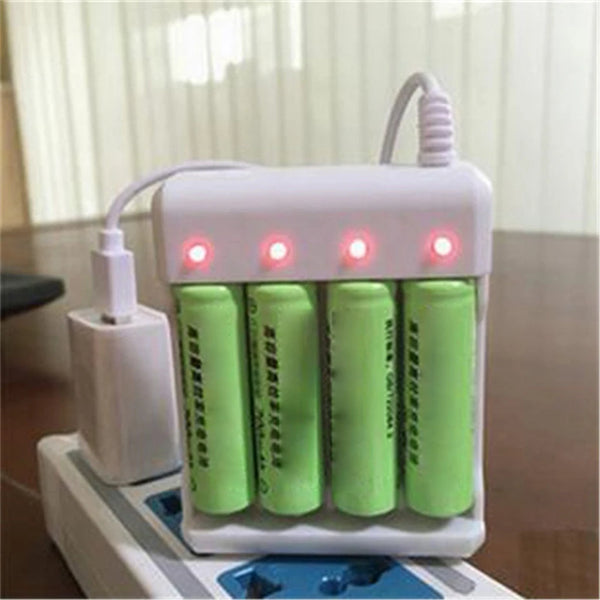 A white universal rechargeable battery charger with multiple slots for AAA and AA cells is shown on a wooden surface.