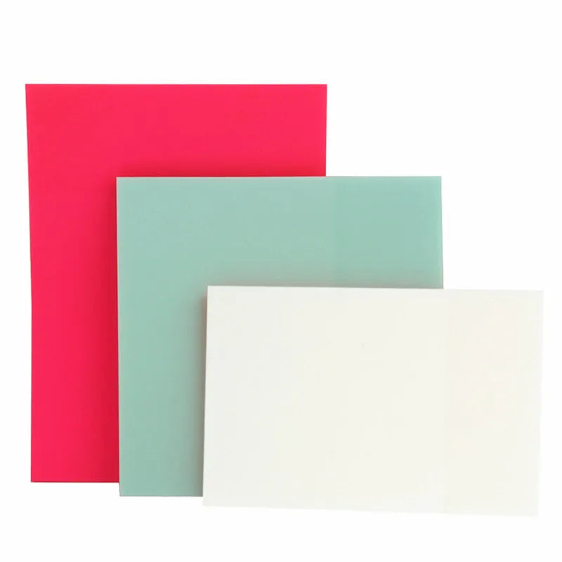 Three sheets of sticky notes in shades of pink, teal, and white stacked together.