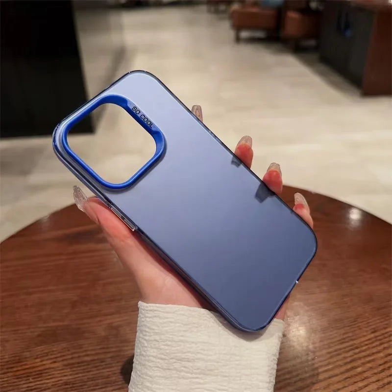A hand holds a blue iPhone case with a matte silicone finish on a wooden table.