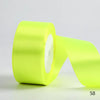 A roll of bright lime green satin ribbon used for gift wrapping and DIY crafts.