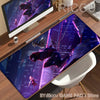 A purple and blue Spider-Man anime desk mat mouse pad displayed on a wooden desk next to a laptop.