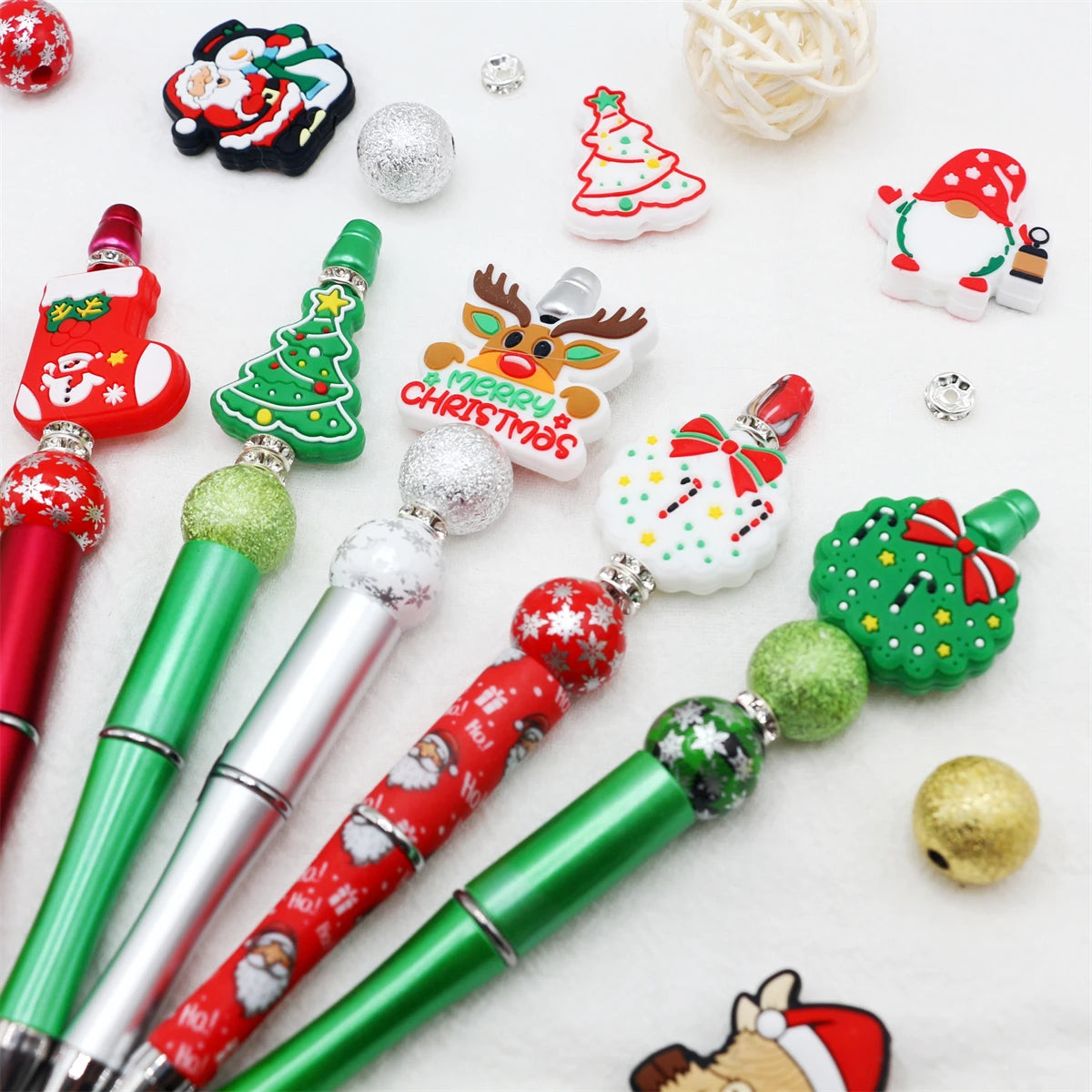 A set of decorative beaded ballpoint pens featuring Christmas and winter themes in red, green, and silver.