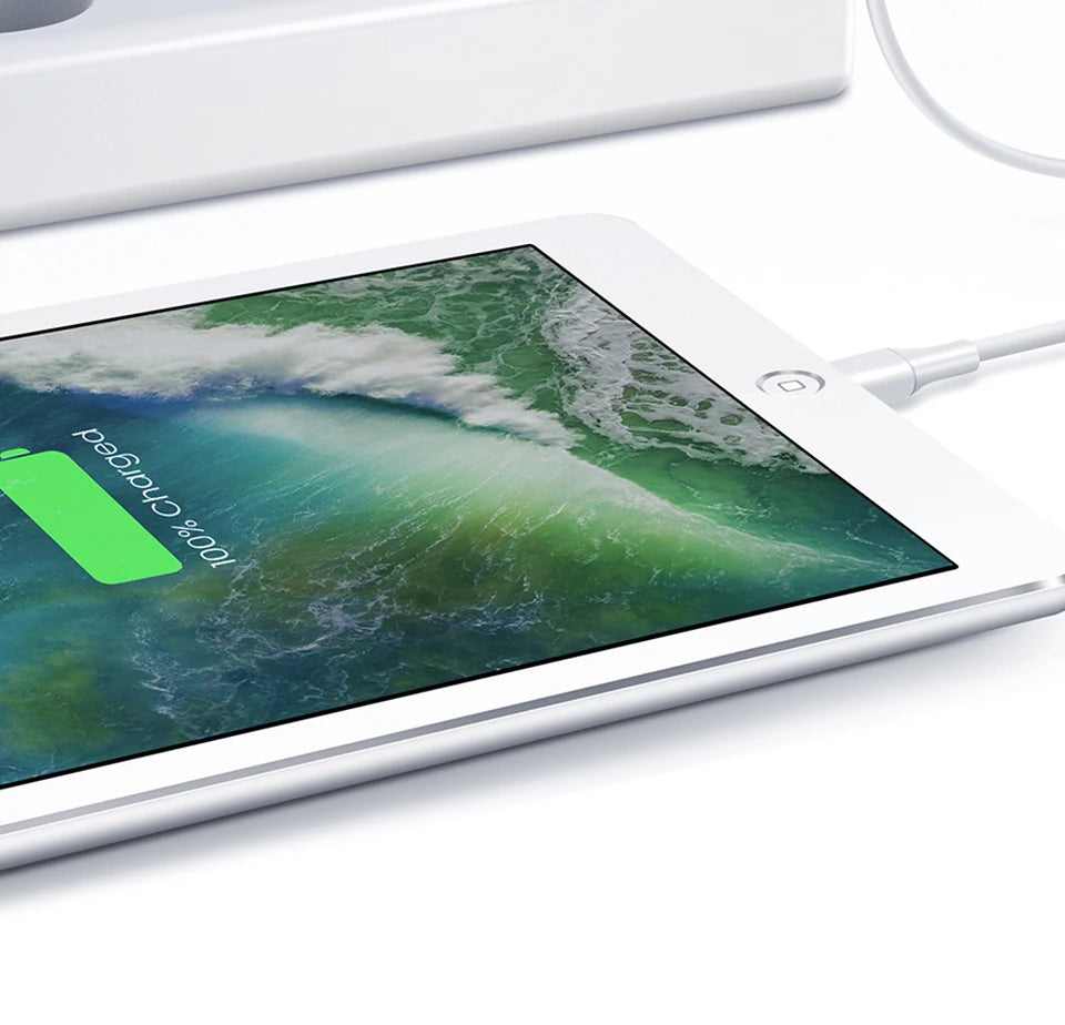 A tablet screen displays a green charging indicator showing 100% charged, next to a USB-C charging cable.