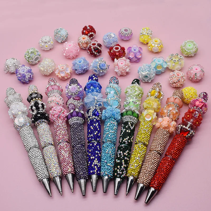 A collection of colorful handmade acrylic flower beads in various shades and sizes arranged on a pink background.