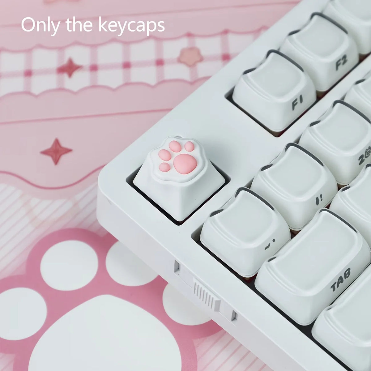 A white keycap puller box showing various pink and white cat paw and heart themed keycaps for MX switches.