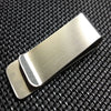 A vintage solid brass money clip with a card holder shown against a black textured background.